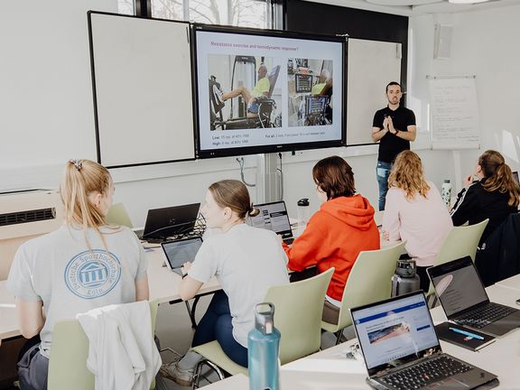 Dozent unterrichtet Studierende im Seminarraum
