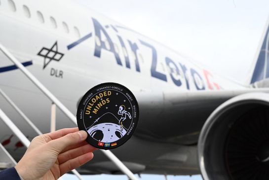Logo des Experiments Unloaded Minds vor dem Flugzeug
