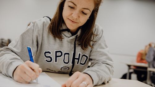 Studentin macht sich im Seminar Notizen
