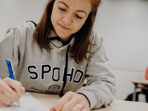 Studentin macht sich im Seminar Notizen

