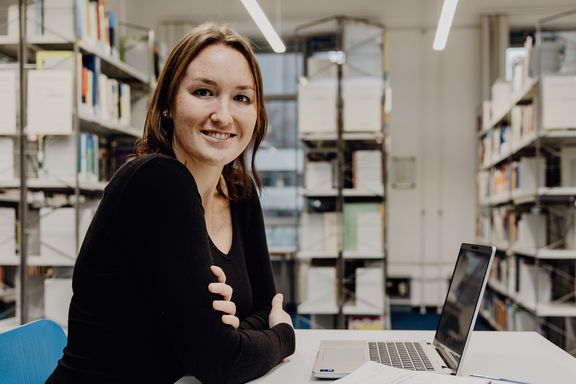Studentin sitzt mit Laptop in der Bibliothek der Deutschen Sporthochschule
