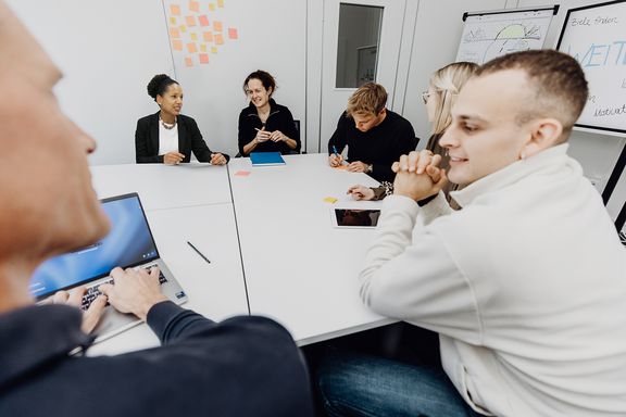 Personen arbeiten gemeinsam im Besprechungsraum
