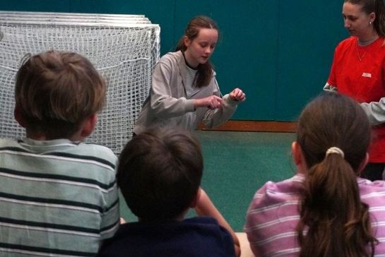 Schülerin macht Pantomime vor drei weitere Schüler*innen
