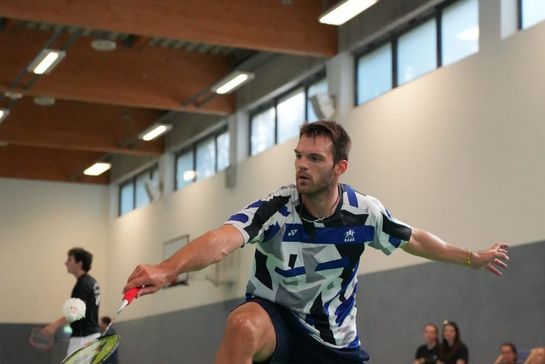 eine Person in Sportkleidung, die Badminton spielt