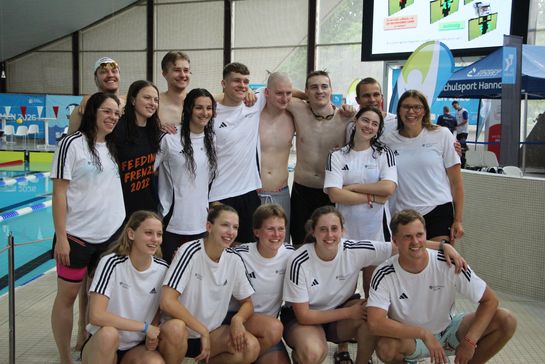 Gruppenbild mit Personen, die sich in einem Schwimmbad befinden
