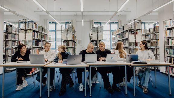 Studierende sitzen mit Laptops in der Bibliothek der Deutschen Sporthochschule
