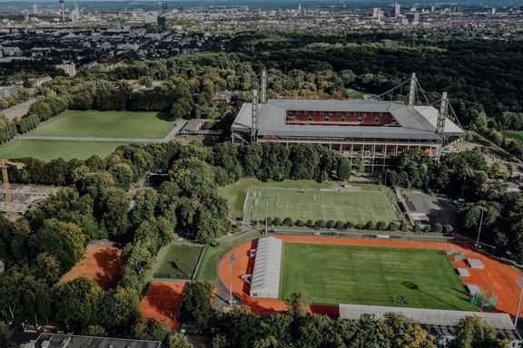 Luftaufnahme des Campus der Deutschen Sporthochschule mit Blick auf Köln im Hintergrund
