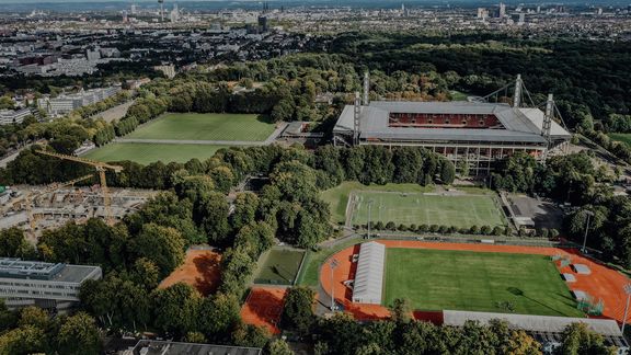 Luftaufnahme des Campus der Deutschen Sporthochschule mit Blick auf Köln im Hintergrund
