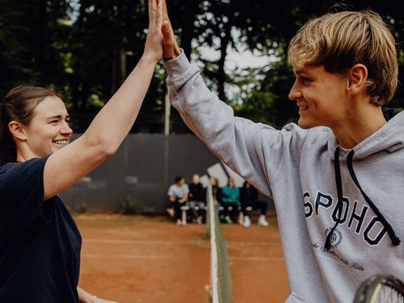 Zwei Tennisspieler klatschen sich am Netz nach dem Match ab

