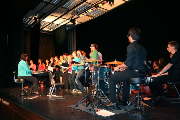 Studierenden des "Sportissimo Chor" singen auf einer Bühne
