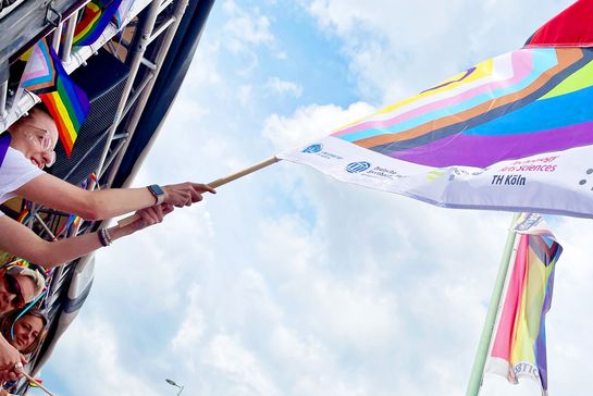 Eine bunte Fahne weht im Wind während des Christopher Street Days in Köln