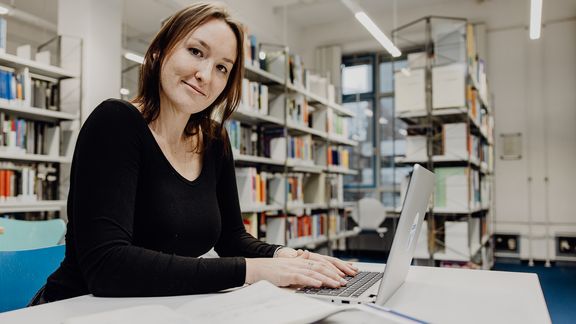Studentin arbeitet mit Laptop in der Bibliothek der Deutschen Sporthochschule
