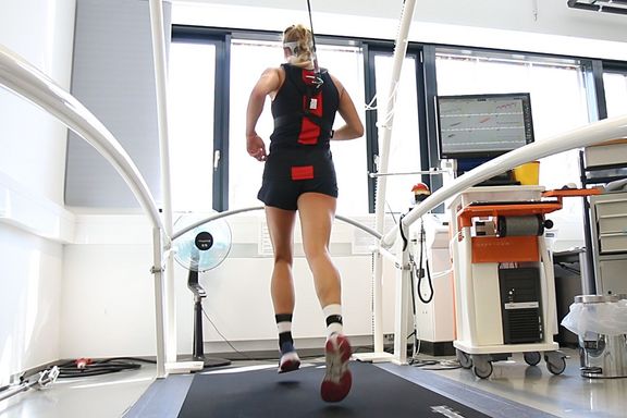 Eine Läuferin auf dem Laufband mit EEG_Kappe
