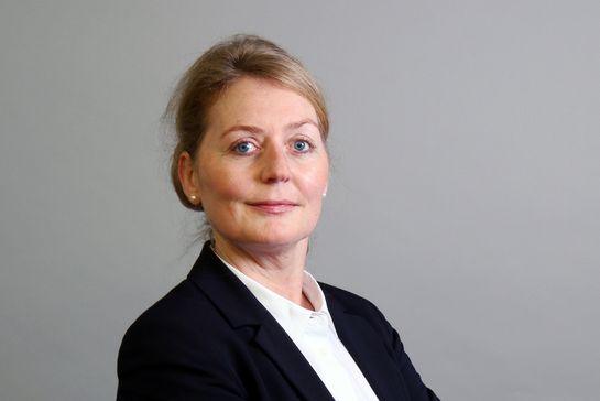 Eine Person in weißer Bluse mit dunklem Blazer
