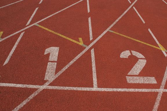Hundert Meter Startlinie auf Tartanbahn mit den markierten Bahnen eins und zwei
