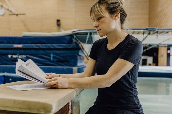 Studentin liest Formular in der Turnhalle der Deutschen Sporthochschule
