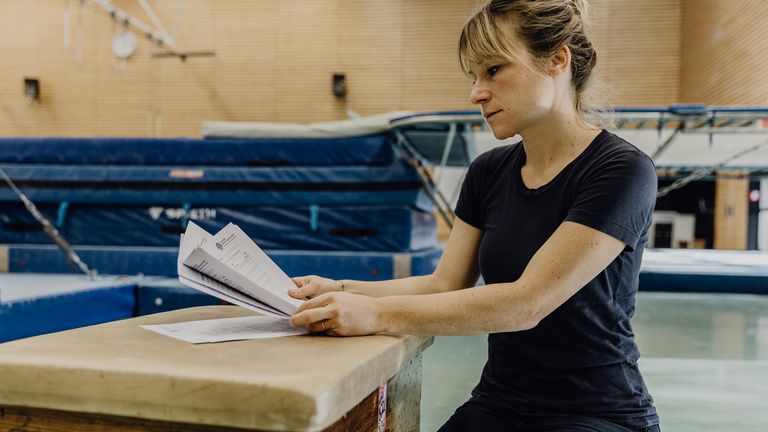 Studentin liest Formular in der Turnhalle der Deutschen Sporthochschule
