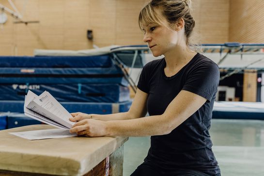 Studentin liest Formular in der Turnhalle der Deutschen Sporthochschule