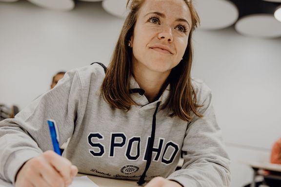 Studentin macht sich im Seminar Notizen
