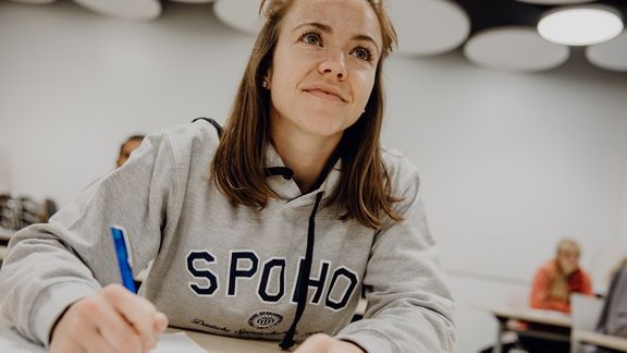 Studentin macht sich im Seminar Notizen
