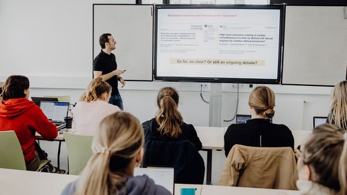 Dozent unterrichtet Studierende im Seminarraum

