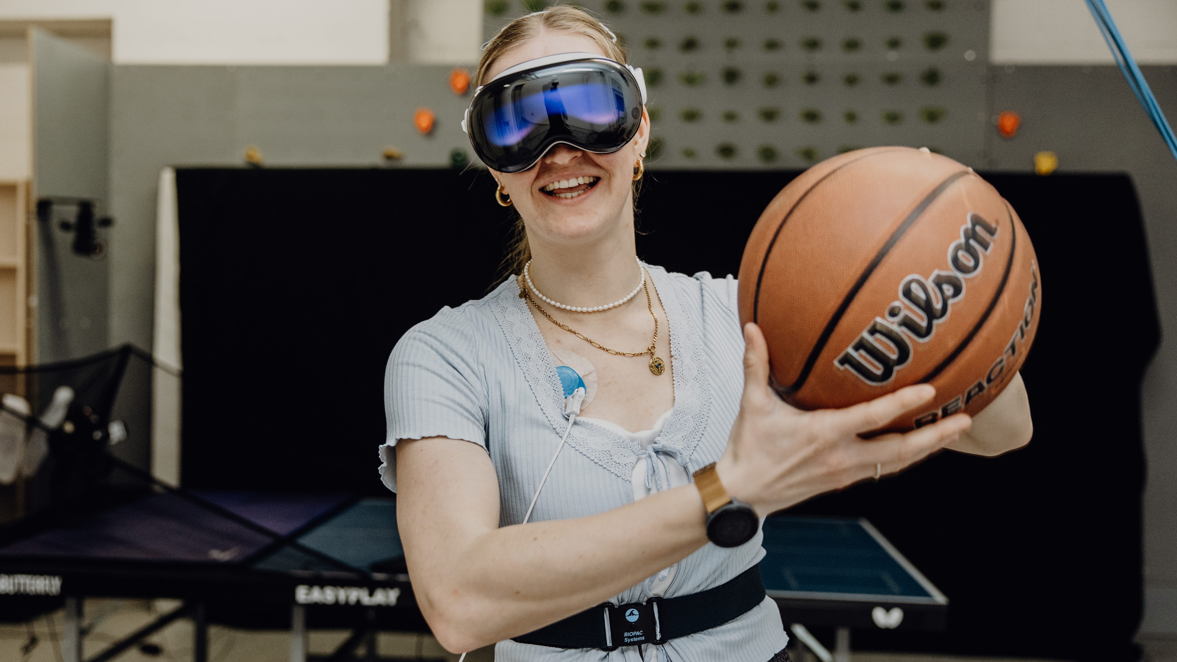 Probandin mit VR-Brille hält Basketball vor sich fest
