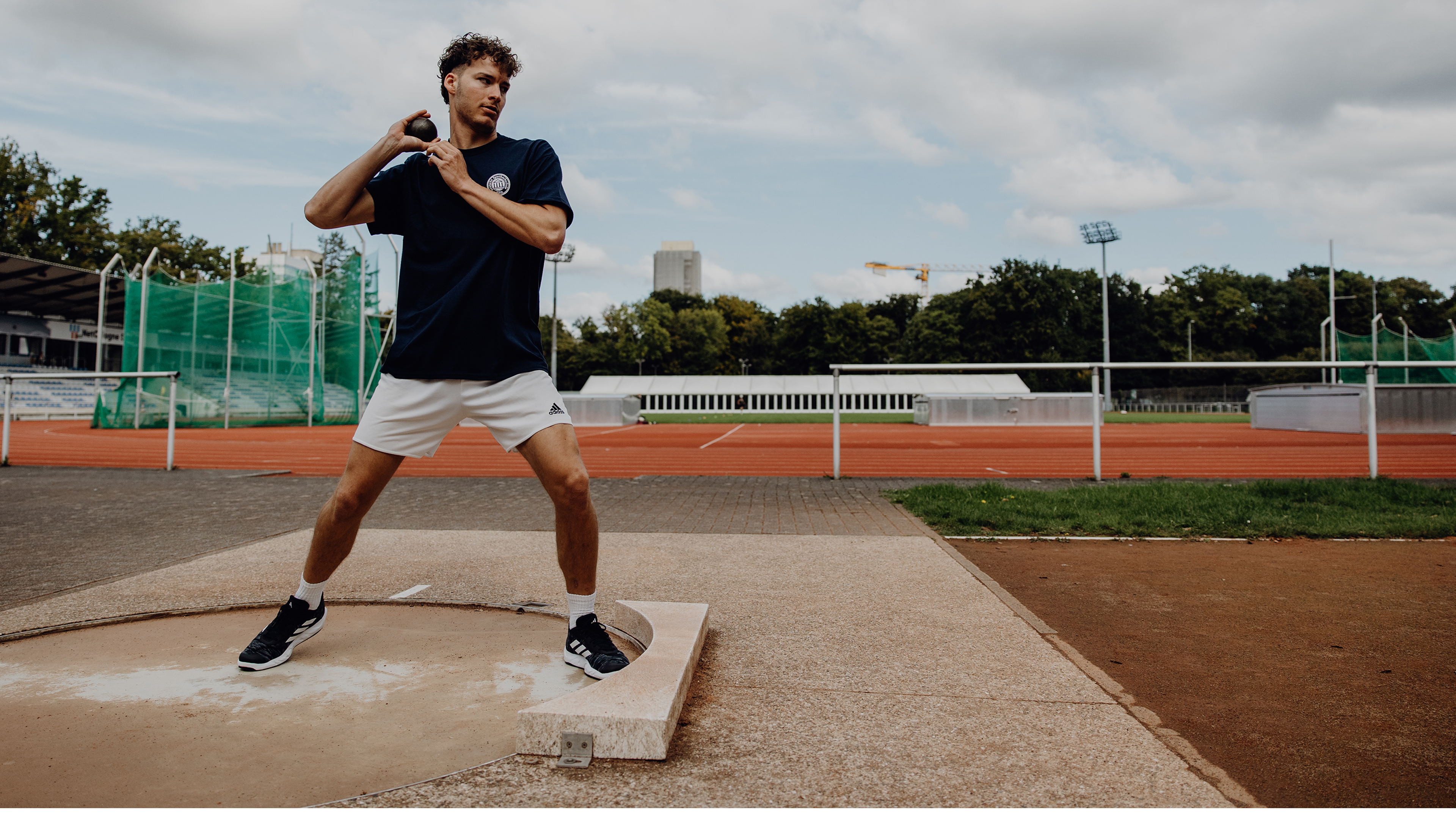 Foto von Kugelstoßer kurz vor dem Abwurf mit Kugel in der Hand 
